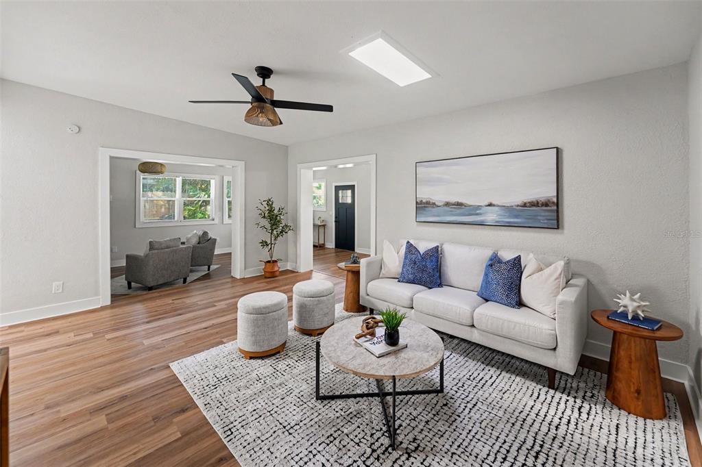 A living room features light gray walls, wood flooring, a white sofa, and a ceiling fan — 340 55TH AVE S, ST PETERSBURG, FL