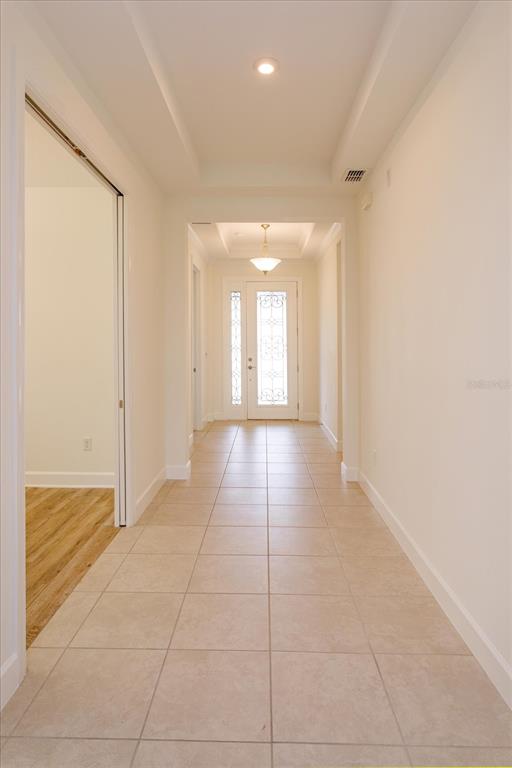 A tiled hallway leads to a front door with a decorative glass insert and transom — 1355 ZEEK RIDGE STREET, CLERMONT, FL