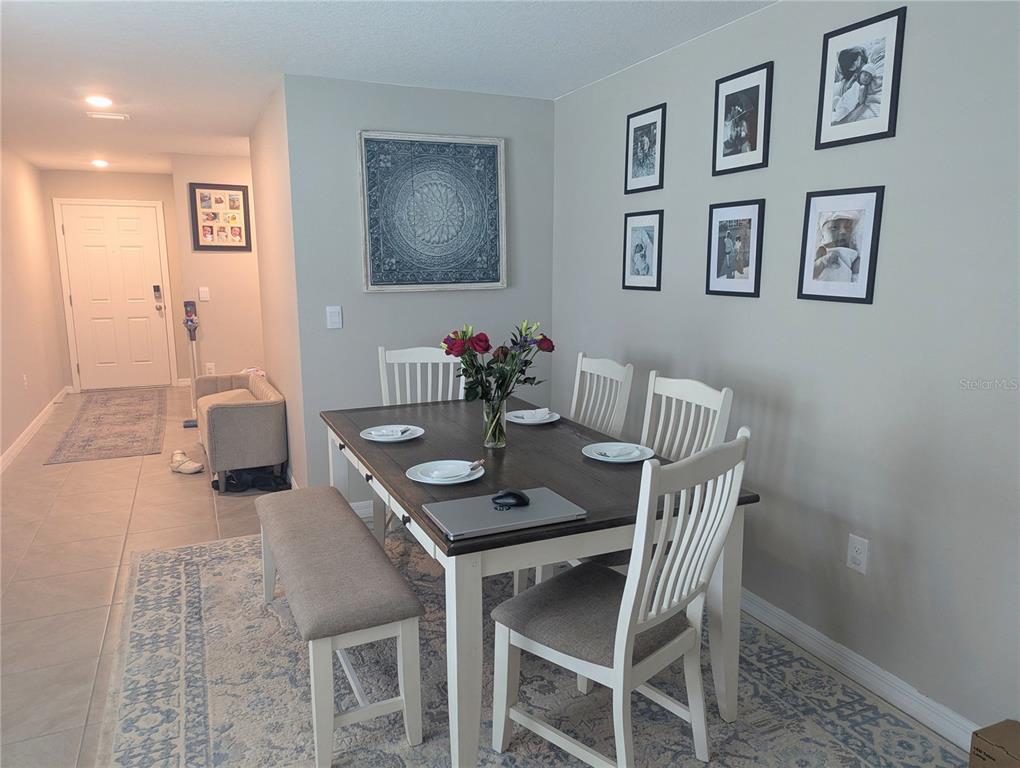 A dining room features a wooden table with chairs and a bench on a rug — 37377 ANGEL WINGS AVENUE, ZEPHYRHILLS, FL