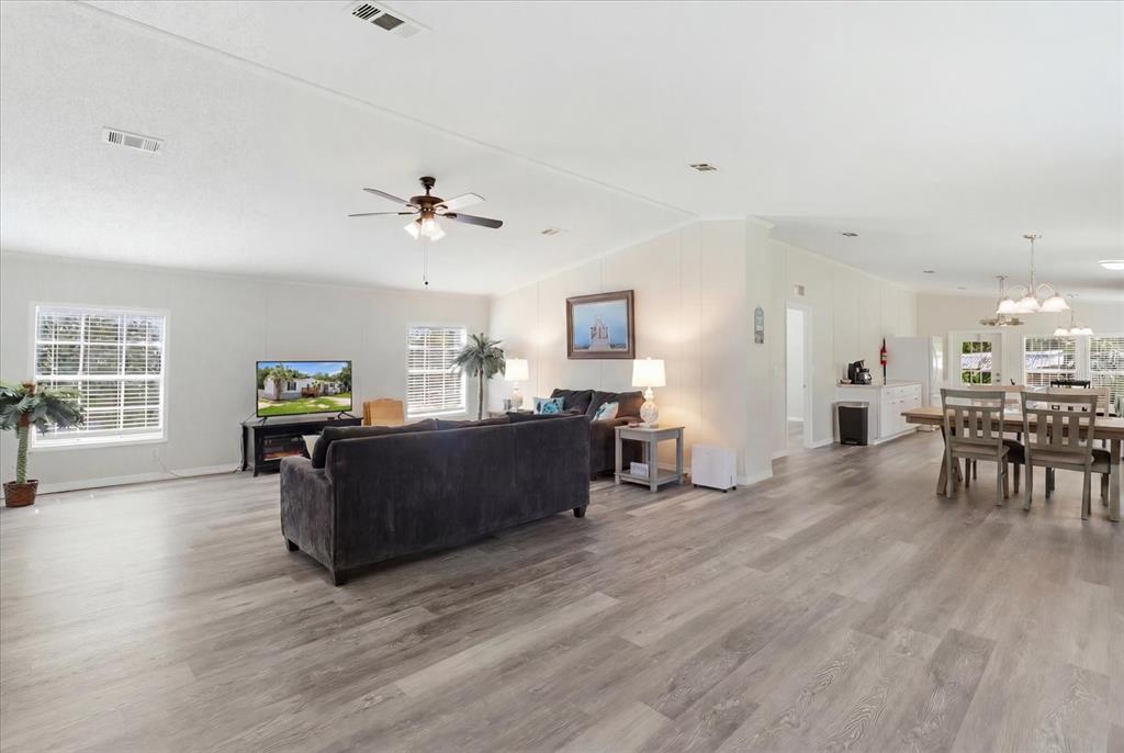 An open-concept living and dining area features light wood-look flooring and a ceiling fan — 4215 N ASHTON TERRACE, CRYSTAL RIVER, FL