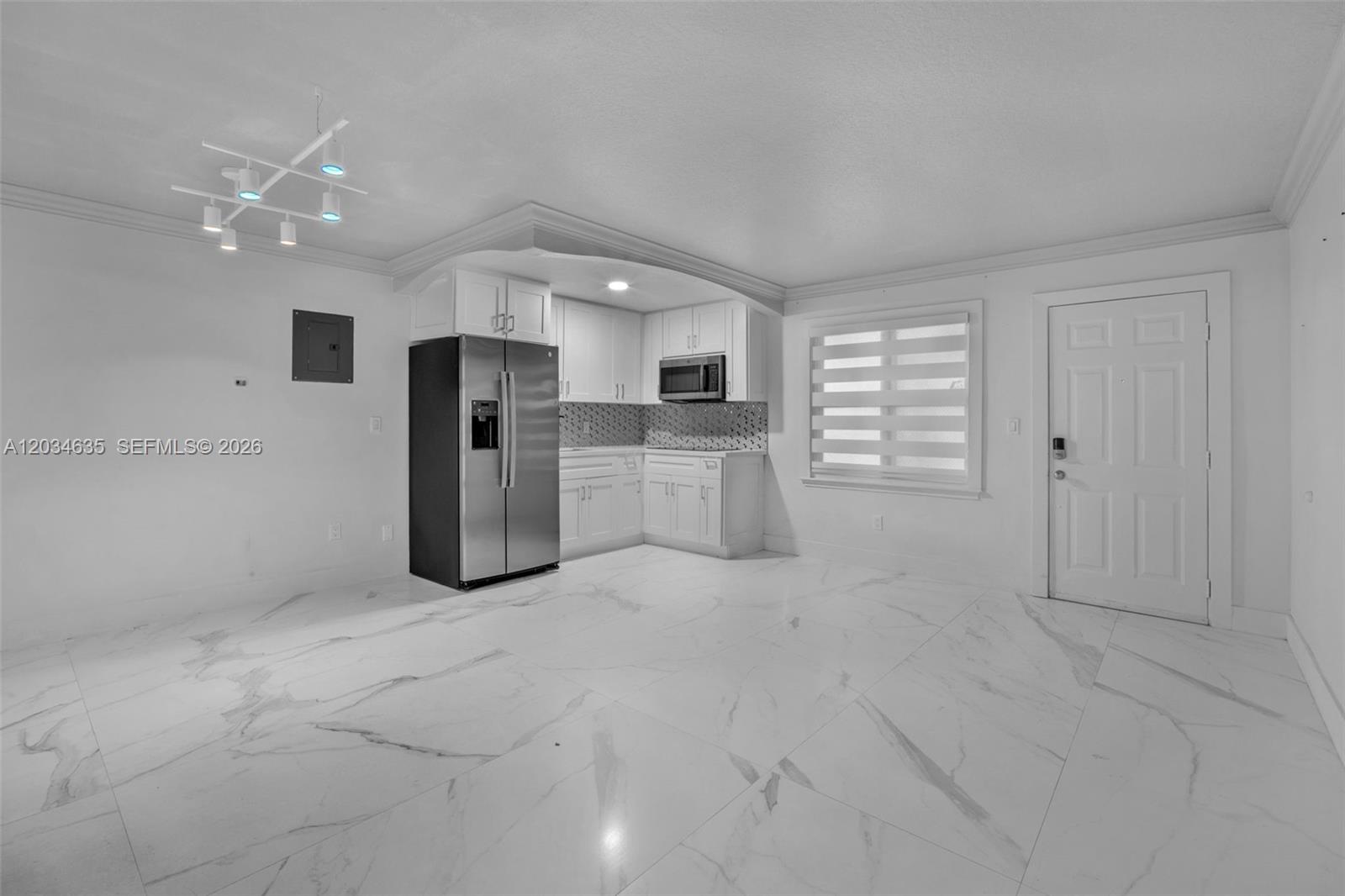 A kitchen with white cabinets, stainless steel appliances, and white marble-look tile flooring — 3245 Virginia St # 16, Miami FL 33133, MIAMI, FL