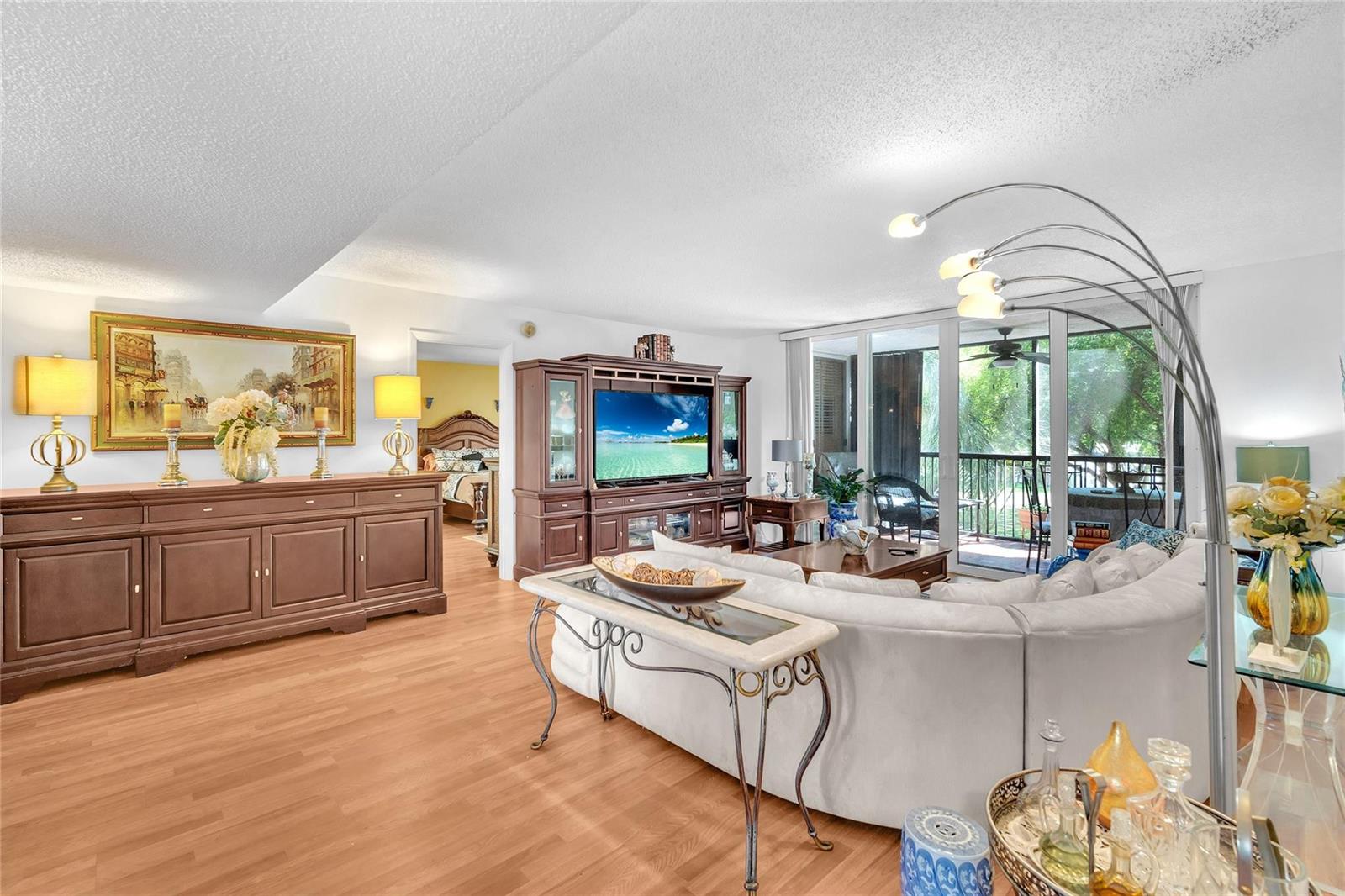 An aerial view of a swimming pool area with lounge chairs, umbrellas, and a pavilion — 3910 Inverrary Boulevard # B, Lauderhill FL 33319, LAUDERHILL, FL