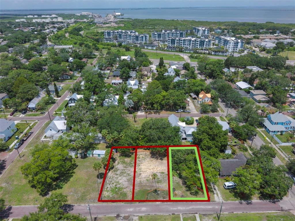 An aerial view shows three adjacent vacant lots in a residential neighborhood near the water — 6905 S SPARKMAN STREET, TAMPA, FL