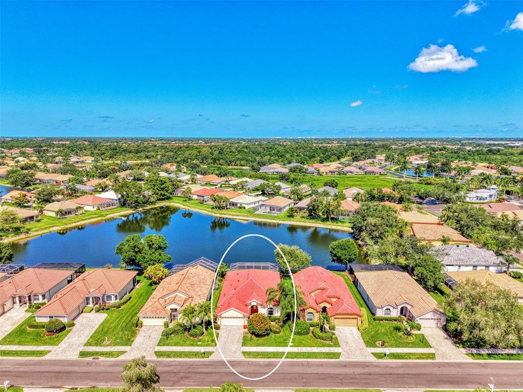 An aerial view shows a single-story house with a red roof and pool cage — 5153 HIGHBURY CIRCLE, SARASOTA, FL