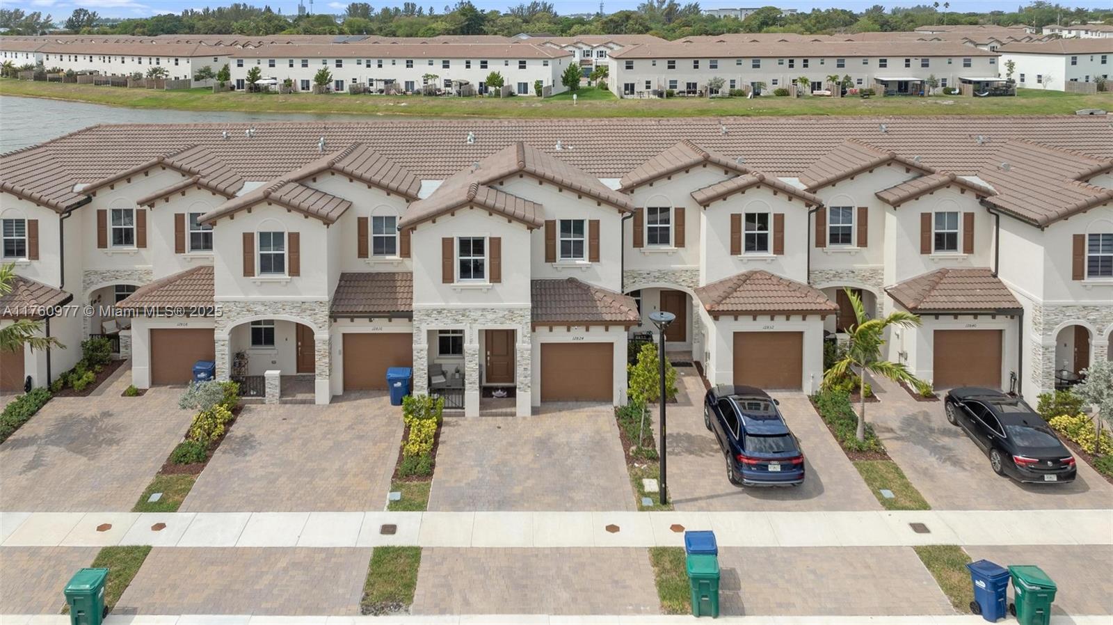 An aerial view shows a row of attached townhouses with brown tile roofs and driveways — 12824 NW 22nd Pl # 12824, Miami FL 33167, MIAMI, FL