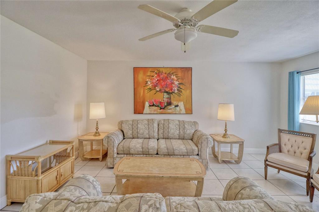 A living room features a patterned sofa, two end tables with lamps, and tile flooring — 101 CAMBRIDGE TRAIL UNIT 196, SUN CITY CENTER, FL