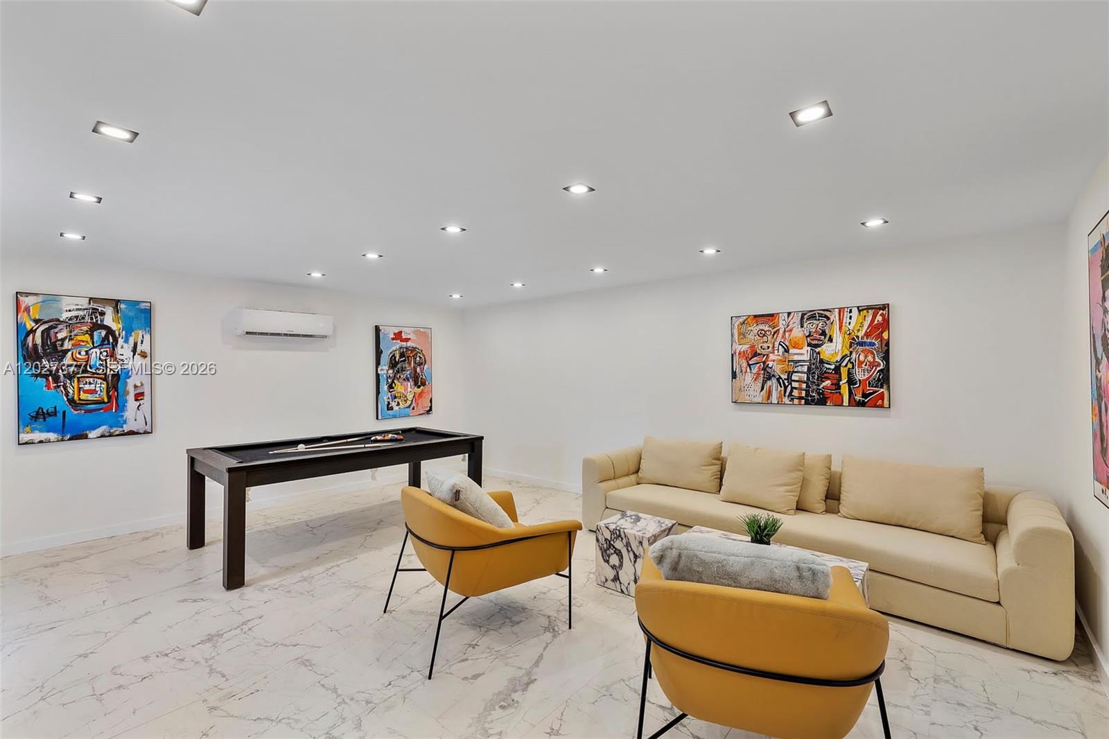 A game room features a pool table, a beige sofa, two yellow chairs, and artwork — 501 NW 46th St, Miami FL 33127, MIAMI, FL