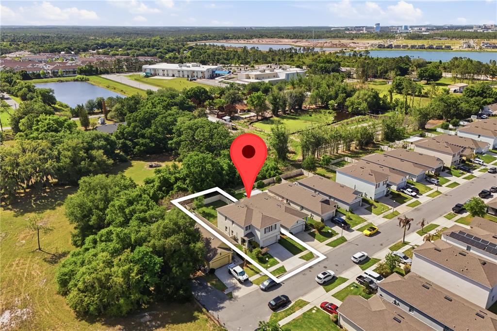 An aerial view shows a two-story house with a white outline and a red pin — 3202 SURFBIRD STREET, KISSIMMEE, FL