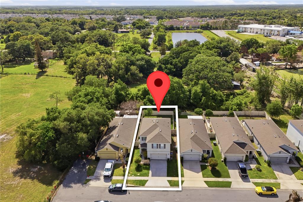 An aerial view shows a single-family home highlighted by a white outline and red pin — 3202 SURFBIRD STREET, KISSIMMEE, FL