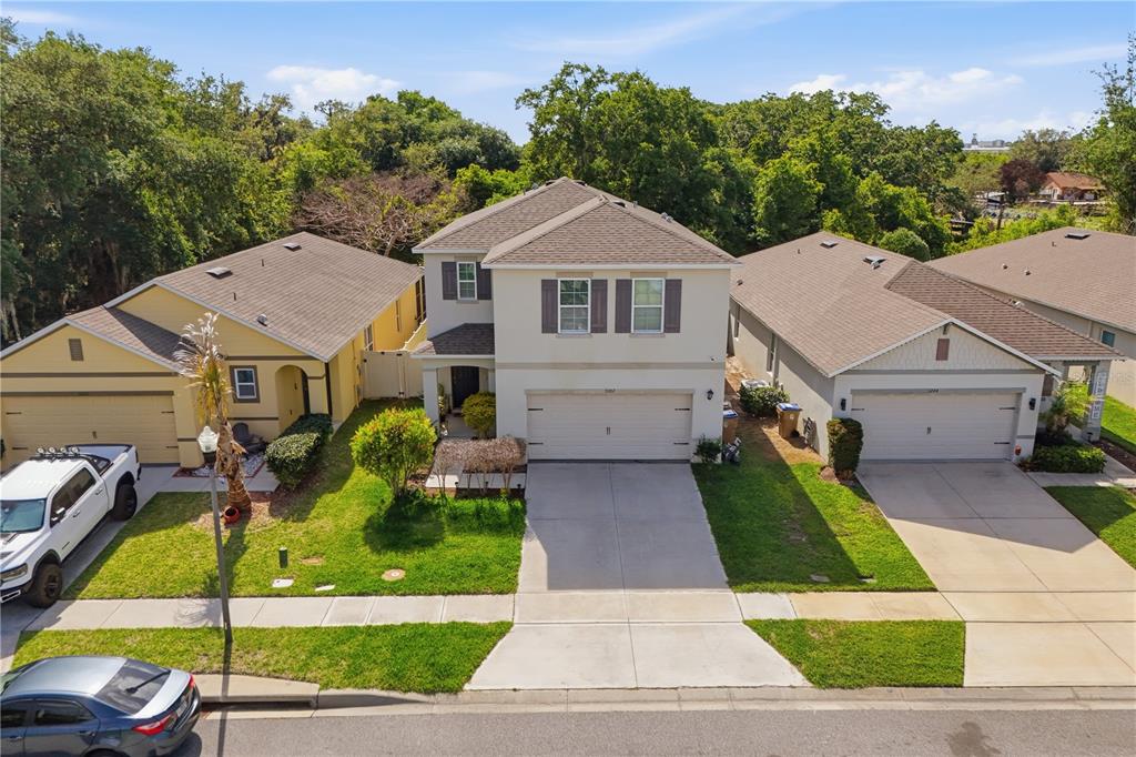 An aerial view of a two-story suburban house situated between two single-story homes — 3202 SURFBIRD STREET, KISSIMMEE, FL