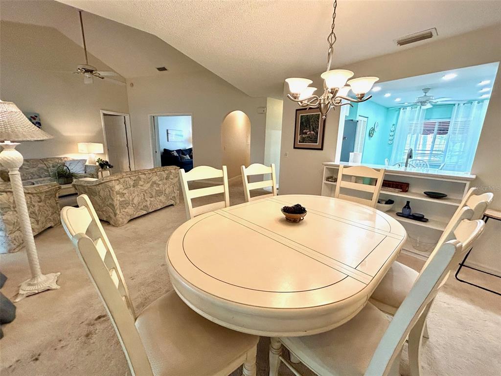 A dining area features a round table with chairs, a mirrored wall, and open shelving — 6101 34TH STREET W UNIT 22H, BRADENTON, FL