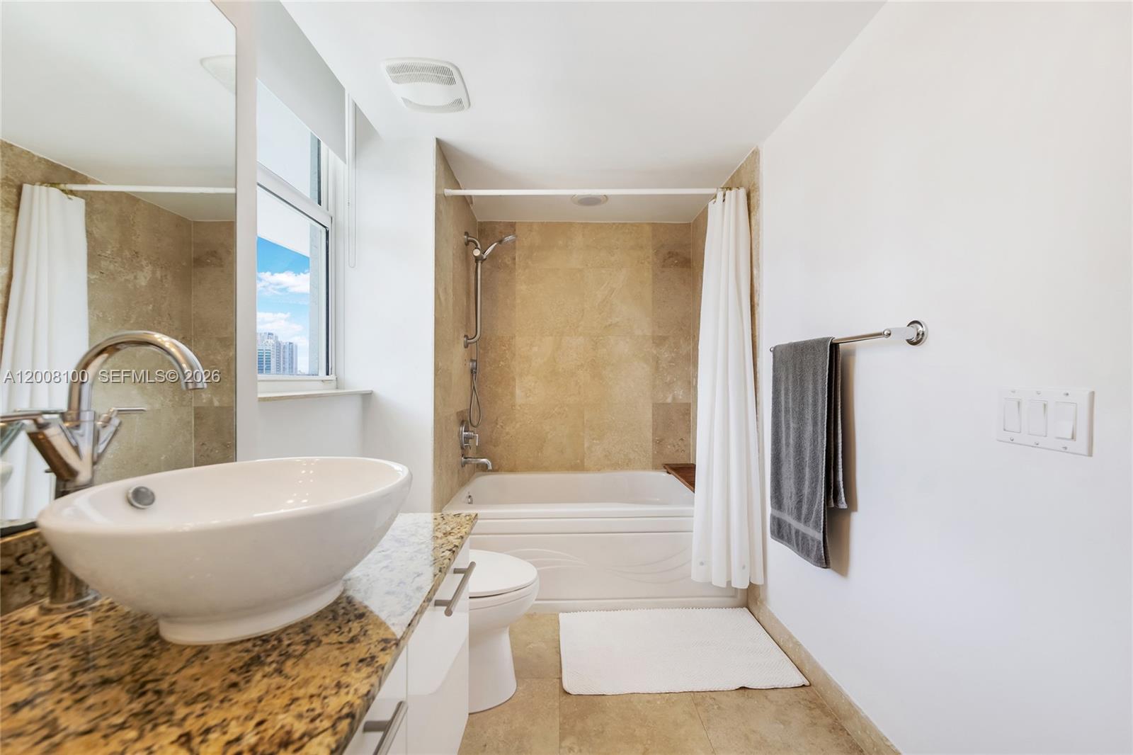 A bathroom features a vessel sink, granite countertop, and a bathtub with a shower curtain — 41 SE 5th St # 504, Miami FL 33131, MIAMI, FL