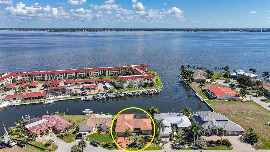 An aerial view shows a waterfront house with a red tile roof circled in yellow — 2750 AQUA COURT, PUNTA GORDA, FL