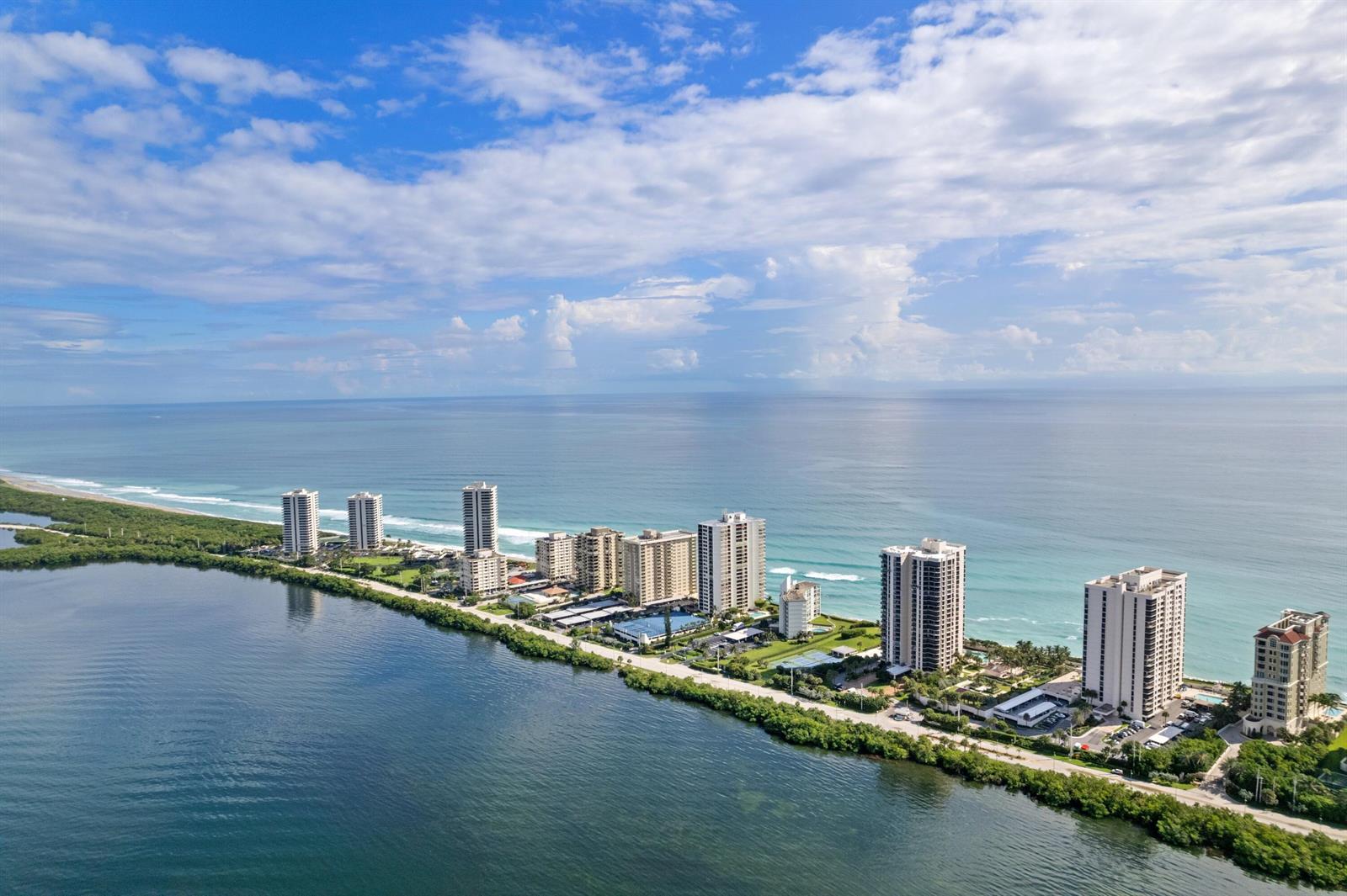 An aerial view shows a narrow strip of land with high-rise buildings between two bodies — 5380 N Ocean Drive # 10d, Riviera Beach FL 33404, RIVIERA BEACH, FL