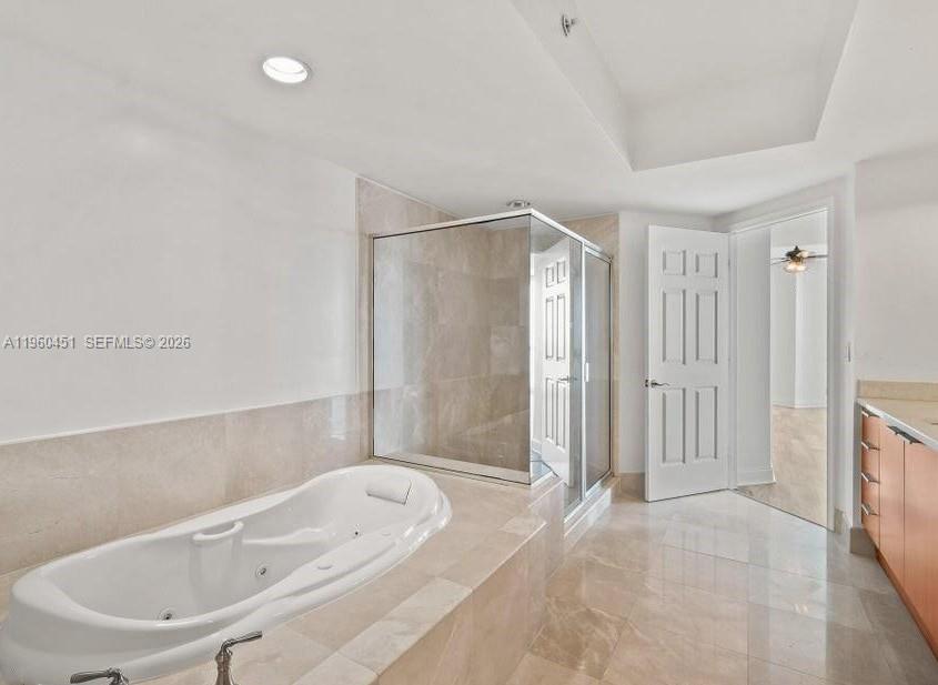 A bathroom featuring a soaking tub, a glass-enclosed shower, and light-colored tile flooring — OTHER CITY - IN THE STATE OF FLORIDA, FL