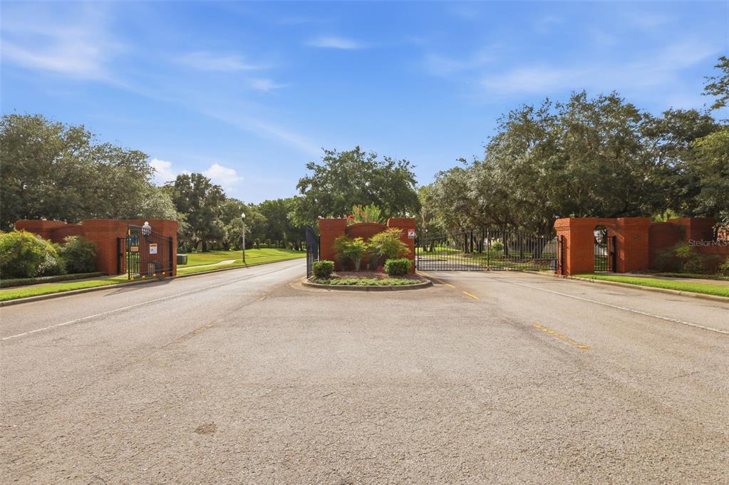 A gated entrance with brick pillars and black metal gates leads into a residential community — 115 RACHEL LIN LANE, ST CLOUD, FL