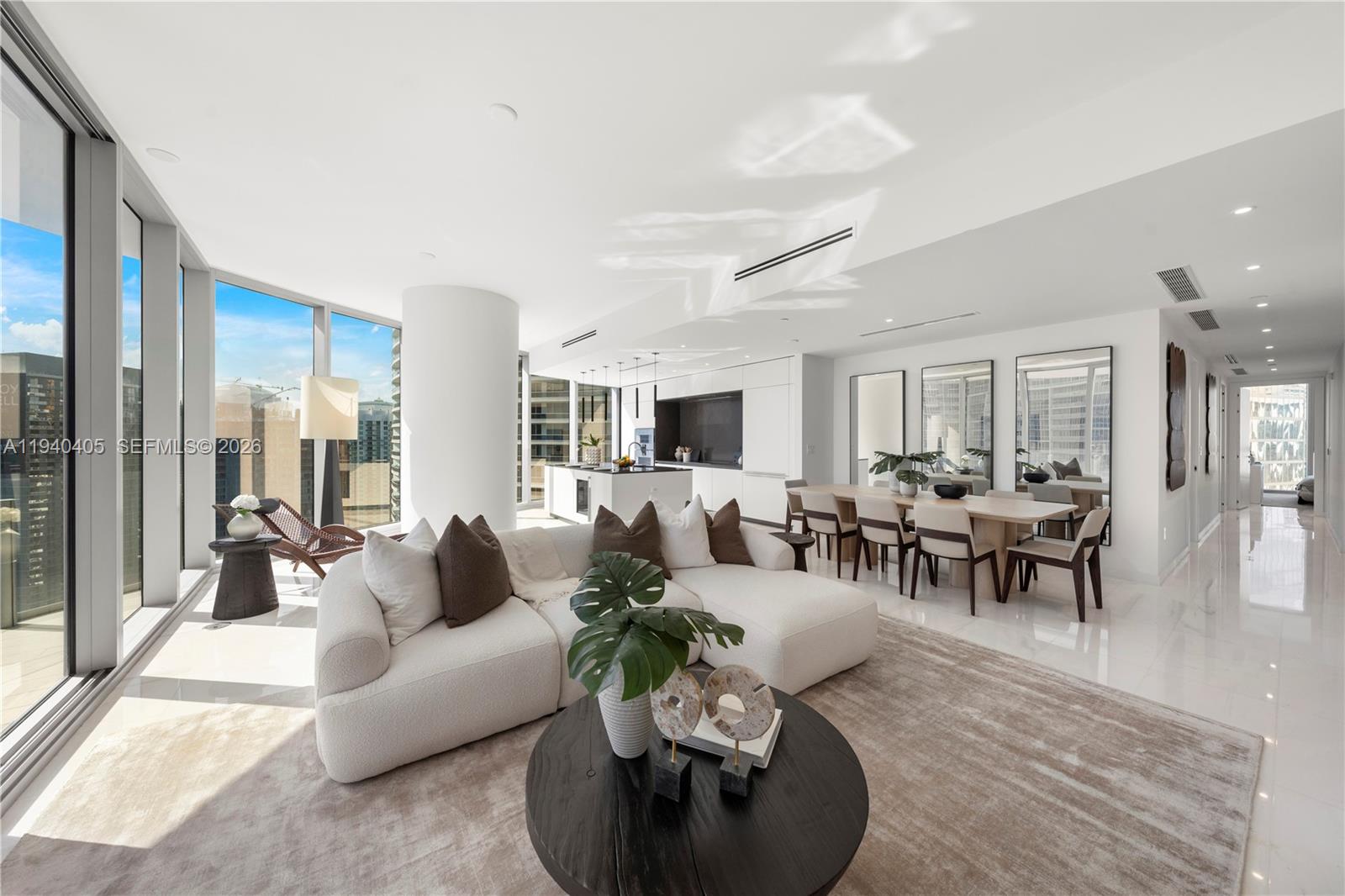 A modern, open-concept living and dining area features floor-to-ceiling windows and white tile flooring — 300 Biscayne Blvd Way # 3407, Miami FL 33131, MIAMI, FL