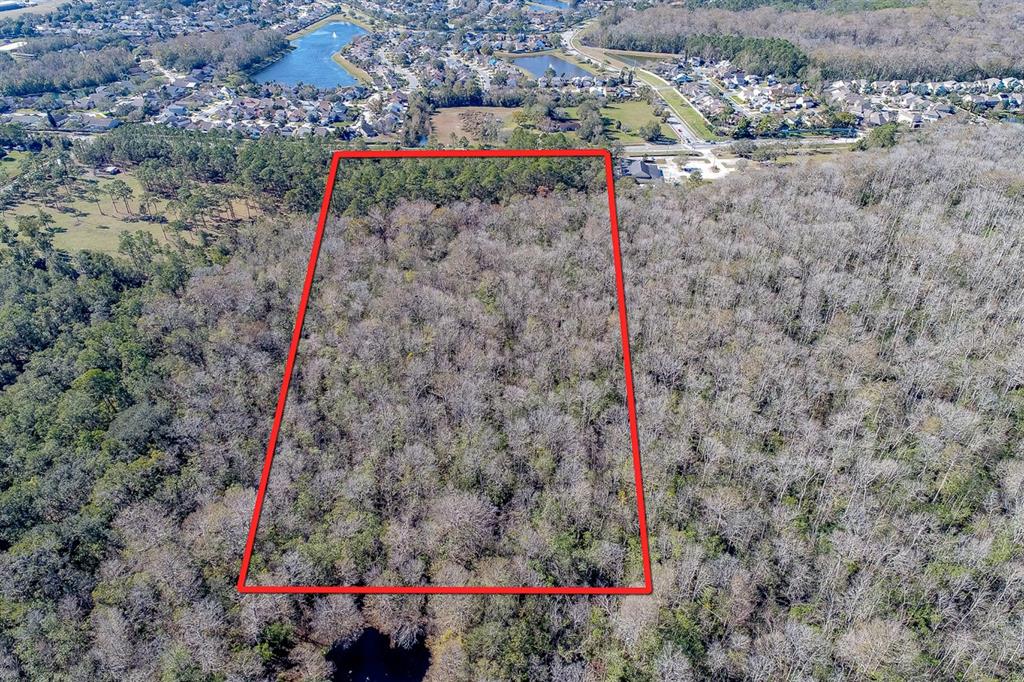 An aerial view shows a rectangular plot of wooded land outlined in red — 400 LONGWOOD LAKE MARY ROAD, LAKE MARY, FL