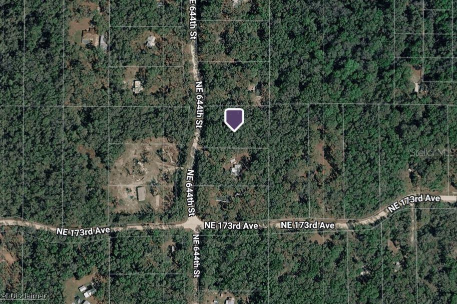 This is an aerial map view showing a wooded lot marked with a purple pin — NE 644TH AVE, OLD TOWN, FL