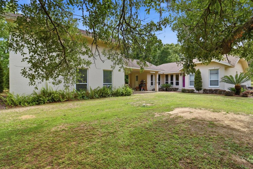 A two-story light-colored house sits in the middle of a large, grassy lawn — 5900 S MAGNOLIA AVENUE, OCALA, FL