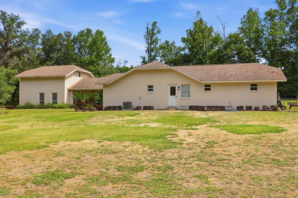 A large, moss-draped oak tree stands in a grassy, open lot under a blue sky — 5900 S MAGNOLIA AVENUE, OCALA, FL