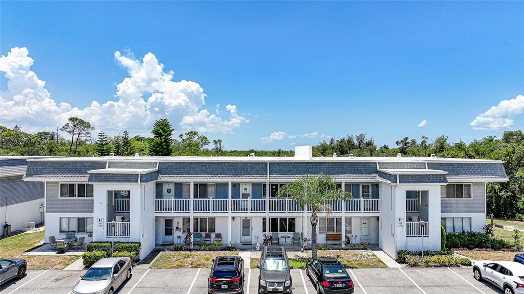 An exterior view of a two-story apartment building with a parking lot in front — 22375 EDGEWATER DRIVE UNIT 236, PUNTA GORDA, FL