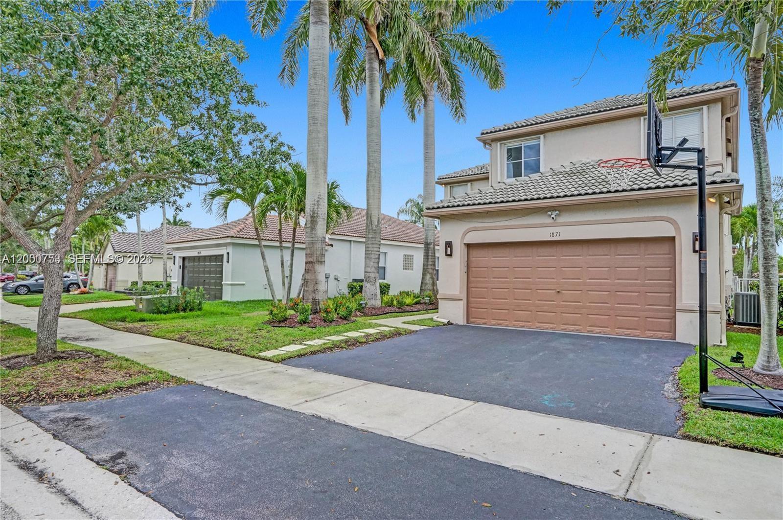 A two-story suburban house with a brown garage door and a basketball hoop in front — 1871 Silverbell Ter, Weston FL 33327, WESTON, FL