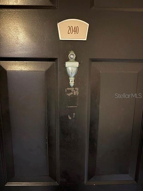 A black door features a silver peephole and a plaque displaying the number 2040 — 202 E SOUTH STREET UNIT 2040, ORLANDO, FL