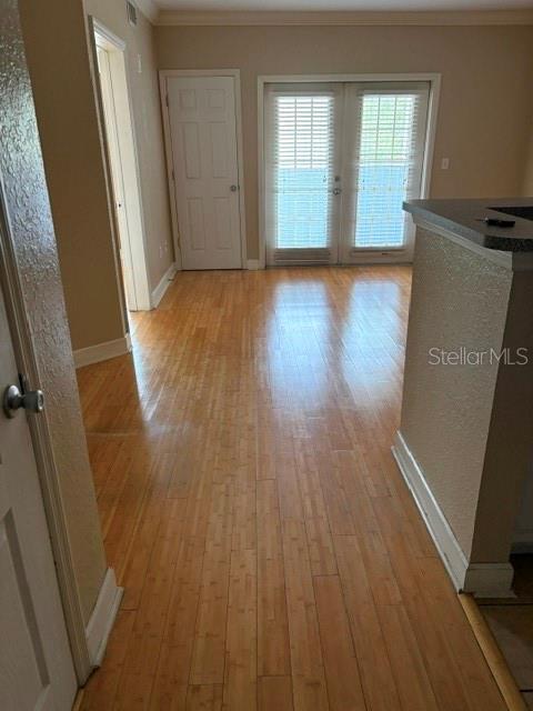 A room with light wood flooring, a white door, and glass sliding doors with blinds — 202 E SOUTH STREET UNIT 2040, ORLANDO, FL