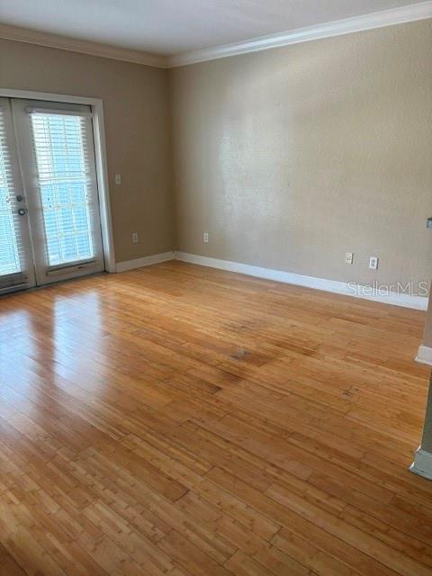 An empty room features light-colored wood flooring, beige walls, and a glass-paned door — 202 E SOUTH STREET UNIT 2040, ORLANDO, FL