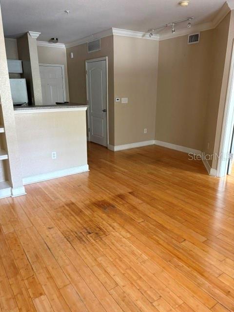 An interior view shows a room with light wood flooring, a kitchen counter, and doors — 202 E SOUTH STREET UNIT 2040, ORLANDO, FL