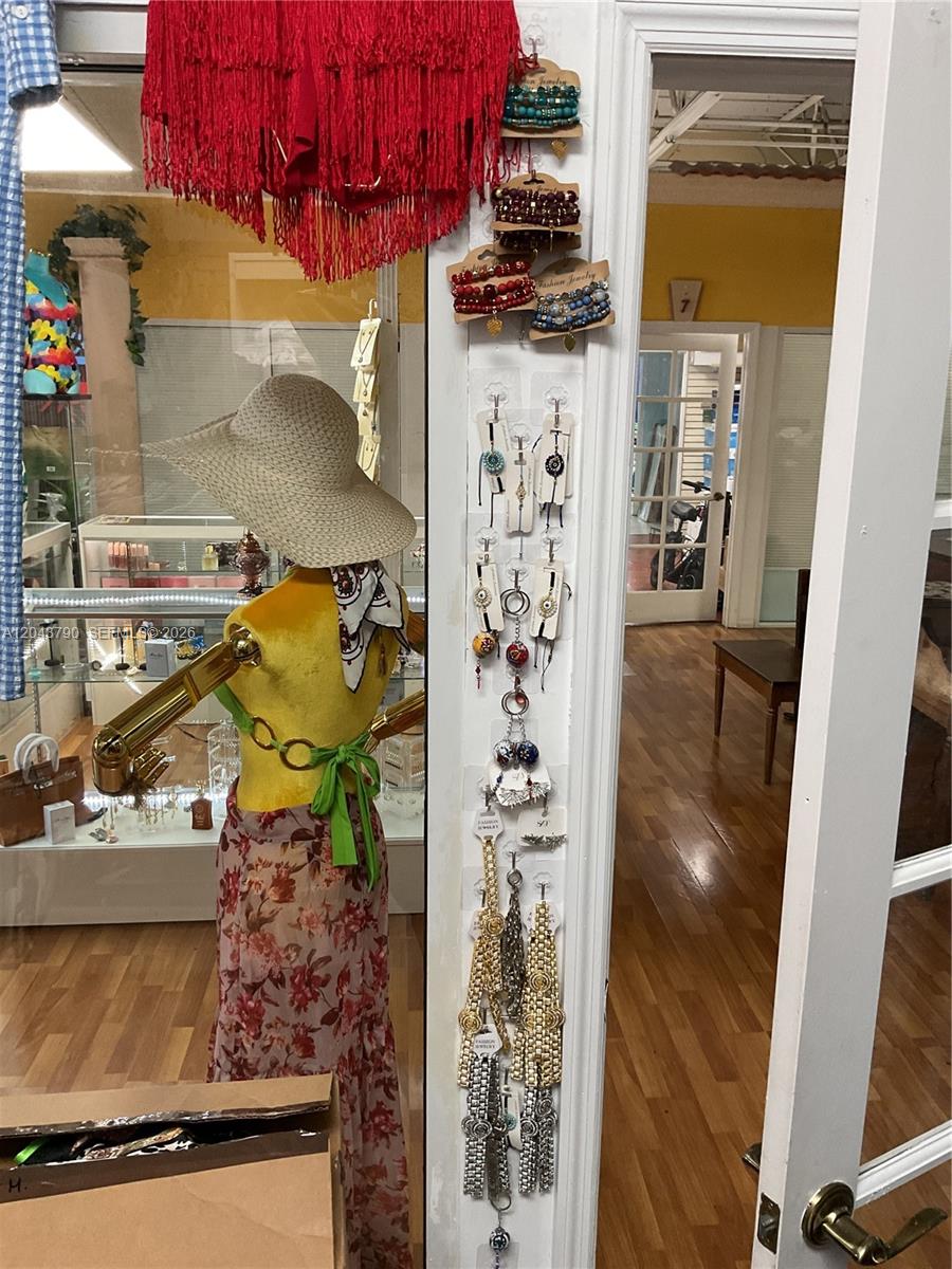 A mannequin wearing a hat and floral skirt stands beside a display of hanging jewelry — 11865 SW 26th St Unit 43-27, Miami FL 33175, MIAMI, FL