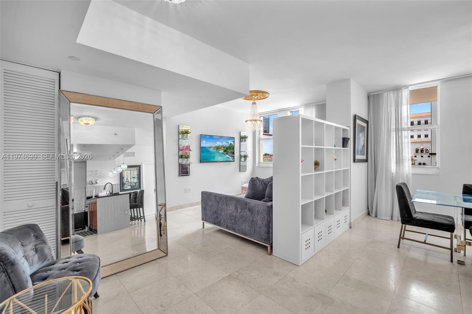 A modern living area features a large mirror, a room divider, and a dining set — 4100 Salzedo St # 519, Coral Gables FL 33146, CORAL GABLES, FL