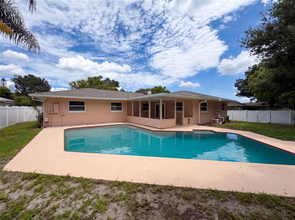 A peach-colored house with a screened-in porch and a swimming pool in the backyard — 2223 CONIFER AVENUE, WINTER PARK, FL
