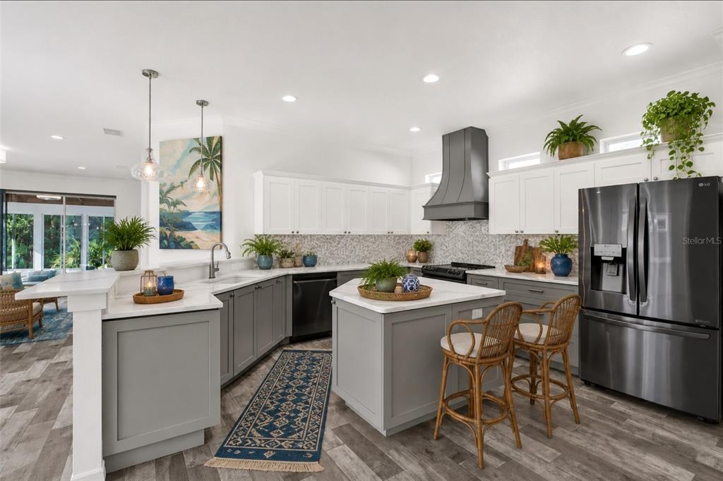 A kitchen features white upper cabinets, gray lower cabinets, a central island, and stainless appliances — 21054 DIAMONTE DR, LAND O LAKES, FL