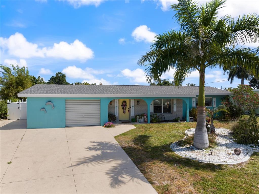 A single-story house with turquoise siding, a yellow front door, and a palm tree — 168 BUCKEYE AVENUE NW, PORT CHARLOTTE, FL