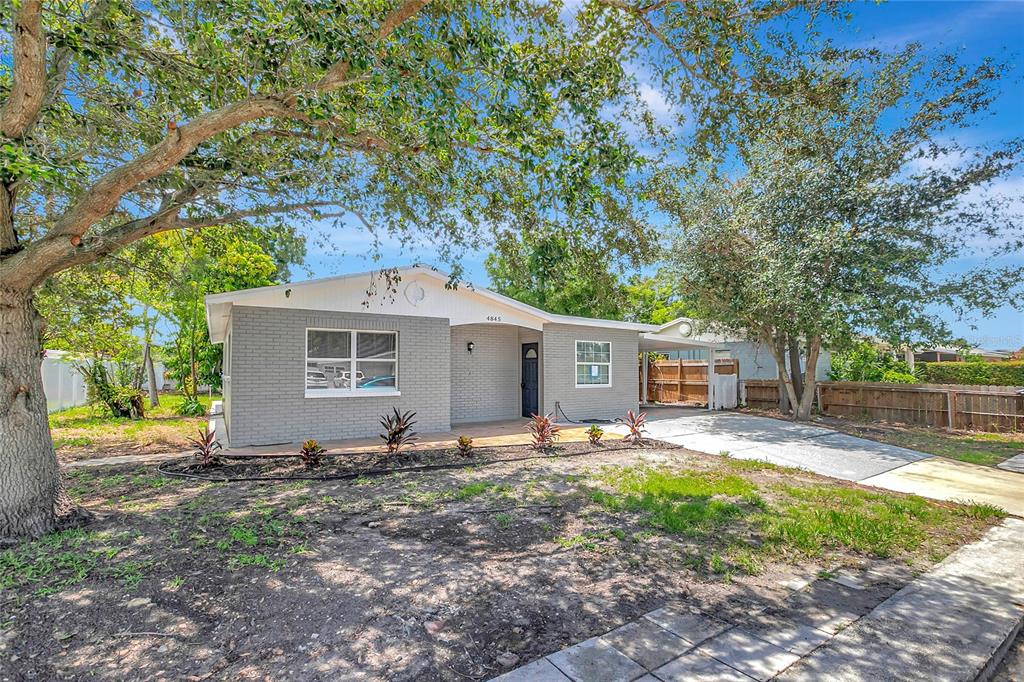 A single-story gray brick house with a front porch and a concrete driveway — 4845 SAN PABLO PLACE, TAMPA, FL