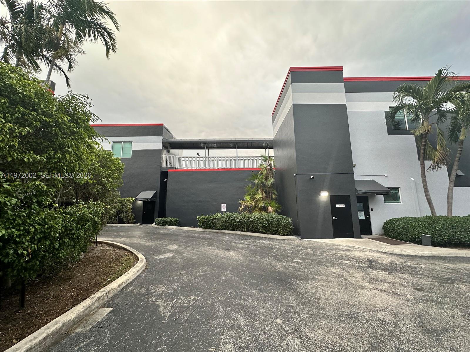 The exterior of a two-story commercial building features a connecting walkway and palm trees — 2950 N 28th Ter, Hollywood FL 33020, HOLLYWOOD, FL