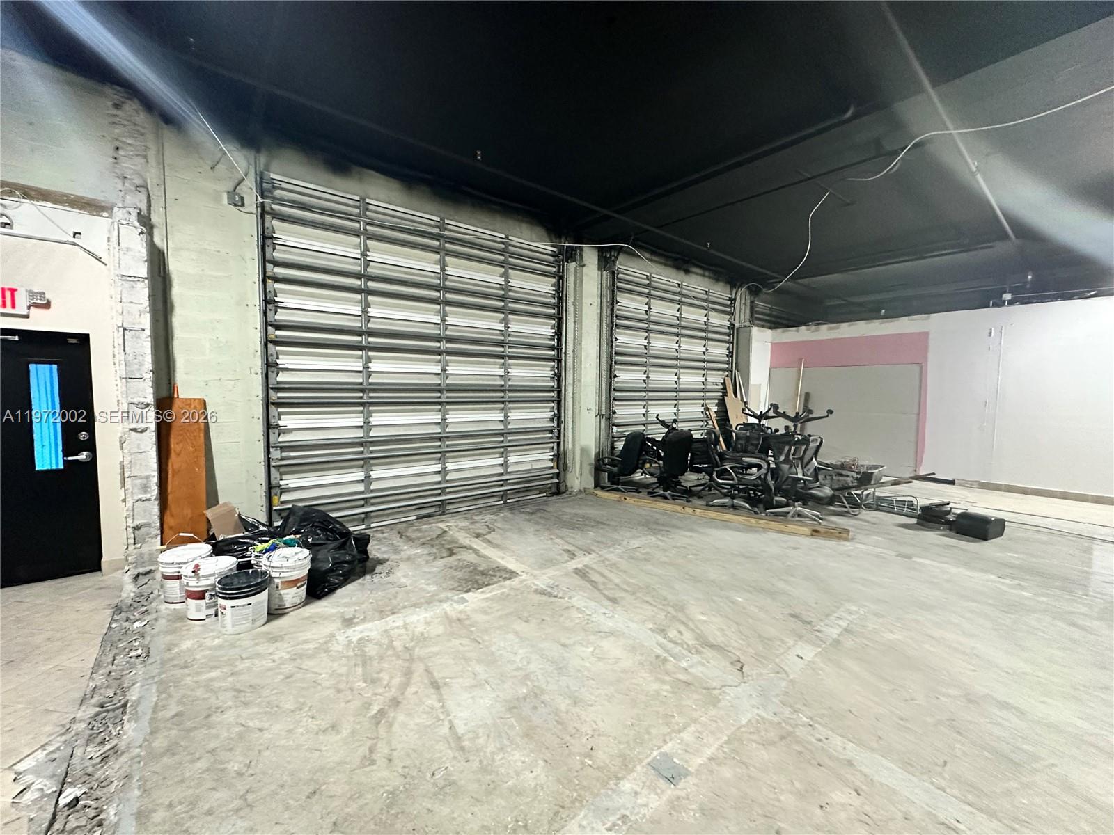 An industrial warehouse space features two large roll-up doors, concrete floors, and exposed ceilings — 2950 N 28th Ter, Hollywood FL 33020, HOLLYWOOD, FL