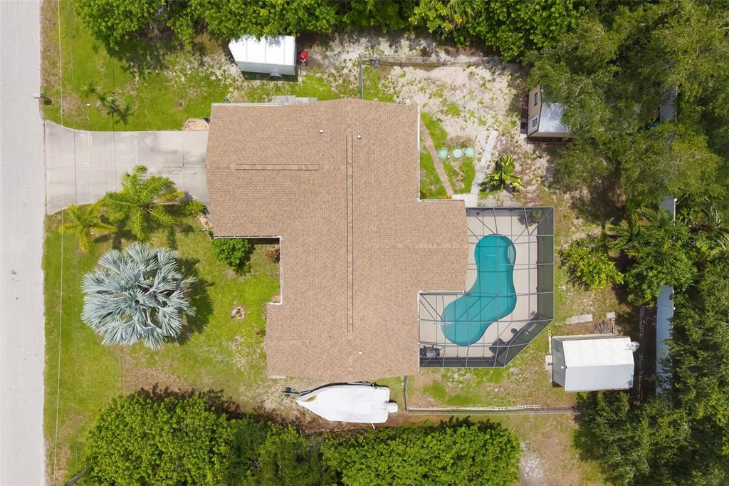 An aerial view shows a house with a shingled roof, pool enclosure, and backyard shed — 7021 FANCY STREET, ENGLEWOOD, FL