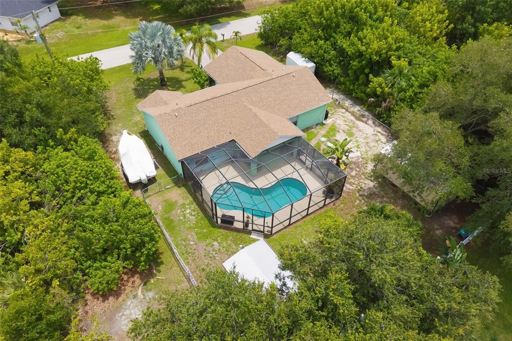 An aerial view of a house with a screened-in pool and a boat parked outside — 7021 FANCY STREET, ENGLEWOOD, FL