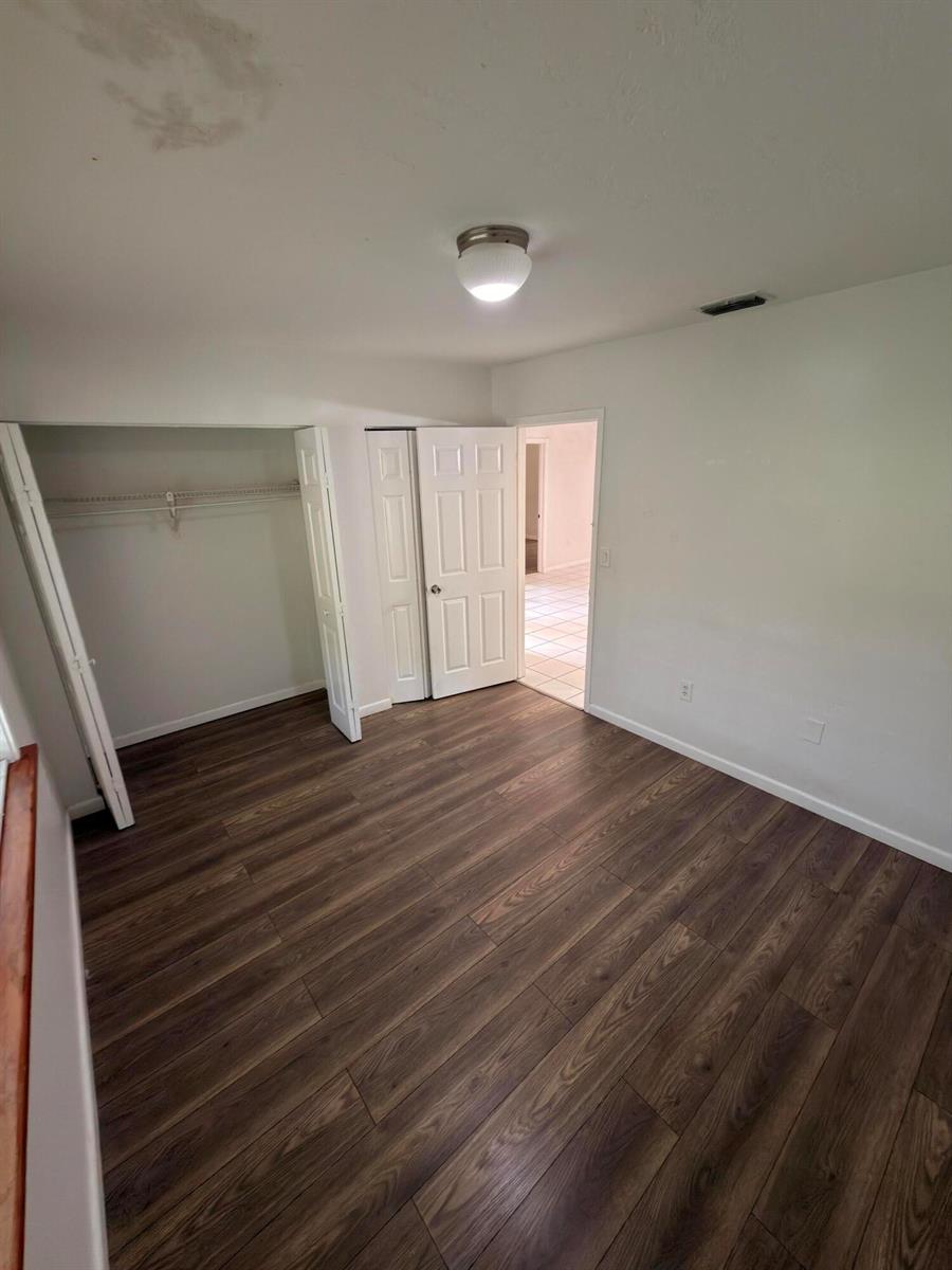 A bedroom features wood-look flooring, a white closet with double doors, and a ceiling light — 15605 SW 74th Cir Drive # 4, Miami FL 33193, MIAMI, FL