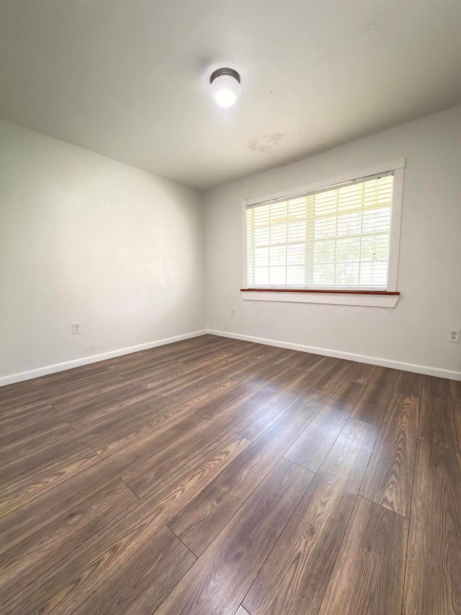 An empty bedroom features light gray walls, a window with blinds, and wood-look flooring — 15605 SW 74th Cir Drive # 4, Miami FL 33193, MIAMI, FL