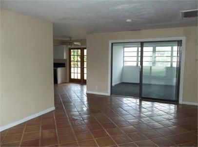 An interior view showing a tiled living area with a sliding glass door to a lanai — 223 SE 14th Place, Deerfield Beach FL 33441, DEERFIELD BEACH, FL