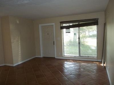 An empty room features tan walls, brown tile flooring, a white door, and a large window — 223 SE 14th Place, Deerfield Beach FL 33441, DEERFIELD BEACH, FL