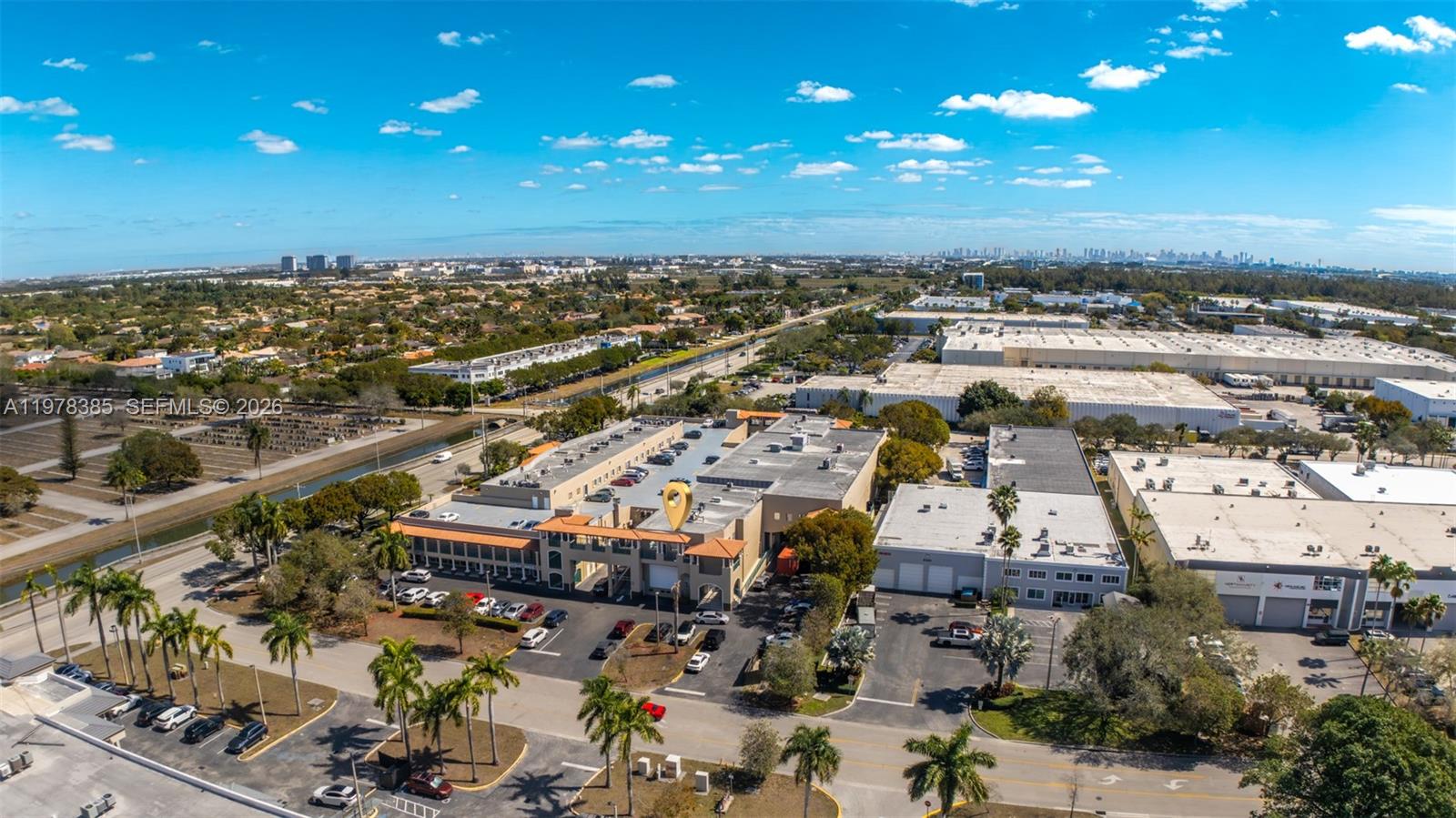 An aerial view shows a commercial building complex with parking lots and surrounding industrial properties — 10200 NW 25th St, Doral FL 33172, DORAL, FL