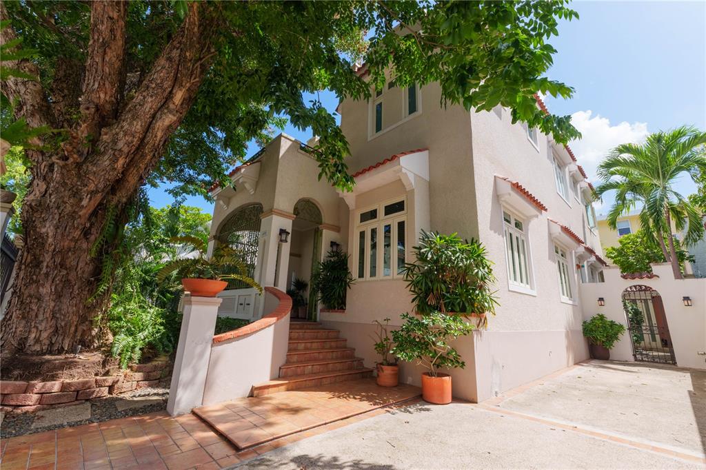 A two-story stucco house with a tiled entrance, arched porch, and a large tree — 655 CONCORDIA, SAN JUAN, PR