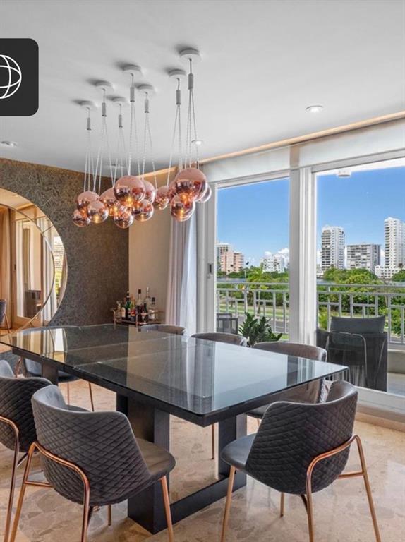 A dining room features a glass table, quilted chairs, and a cluster of copper pendant lights — 548 Hoare St. LAGUNA UNIT 3, SAN JUAN, PR