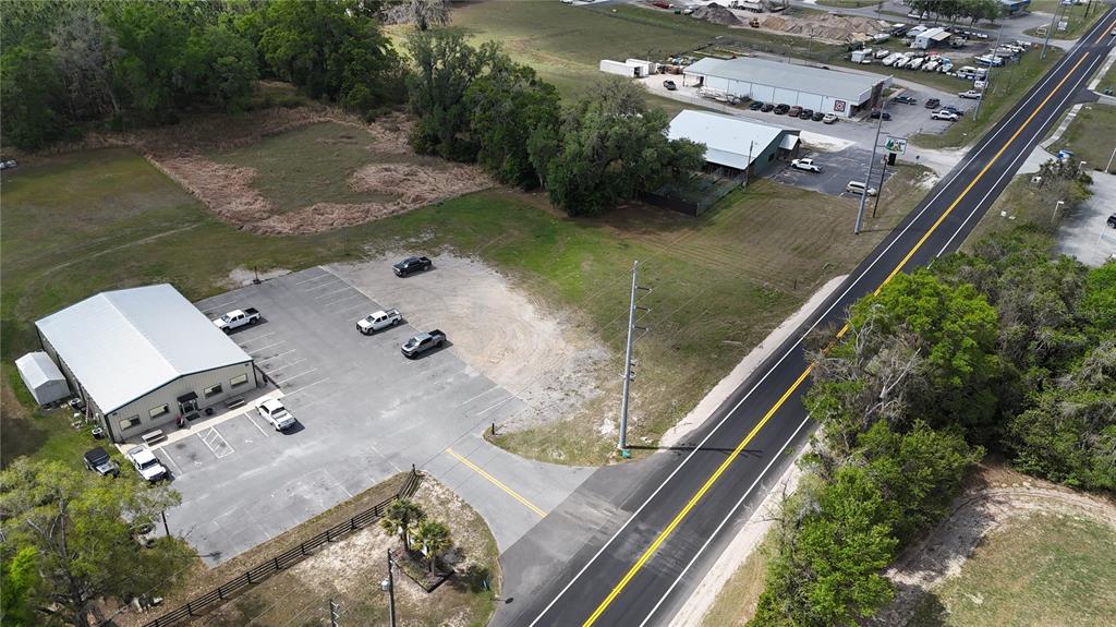 An aerial view shows a commercial building with a parking lot next to a road — 535 SE STATE ROAD 26, TRENTON, FL