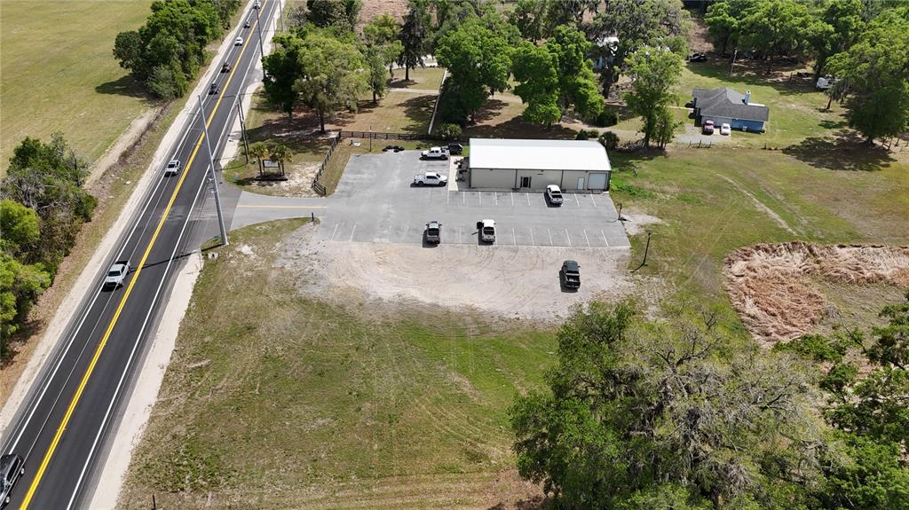 An aerial view shows a commercial building with a parking lot next to a road — 535 SE STATE ROAD 26, TRENTON, FL